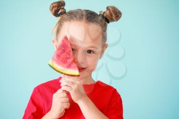 Cute little girl with slice of fresh watermelon on color background�