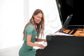 Young woman playing grand piano at the concert�