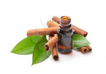 Aromatic cinnamon sticks and essential oil on white background�