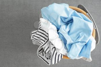 Basket with dirty laundry on grey background�