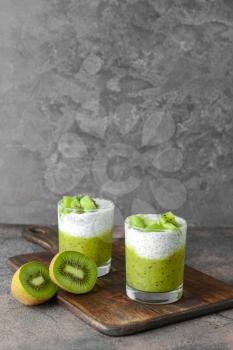 Glasses with tasty kiwi dessert on grey background�