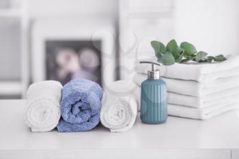 Soft clean towels with soap on table in bathroom�