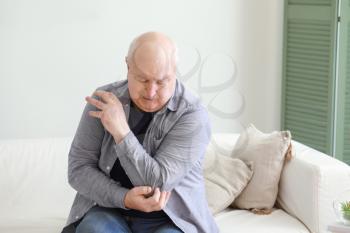 Senior man suffering from pain in elbow at home�