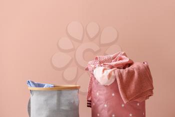 Baskets with laundry on color background�