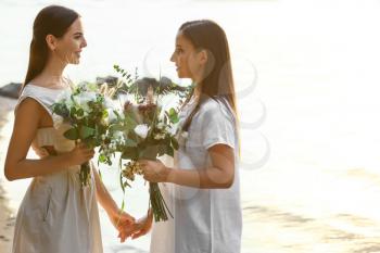 Beautiful lesbian couple on their wedding day near river�