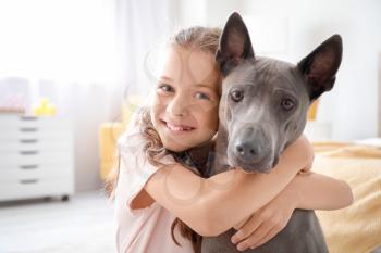 Little girl with cute dog at home�