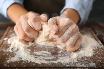 Woman kneading flour in kitchen, closeup�
