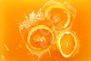 Falling of orange slices into juice, top view�
