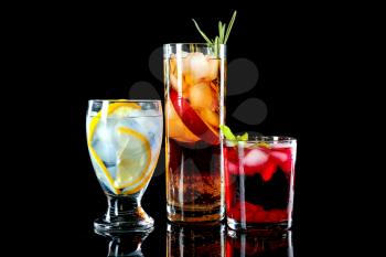 Glasses of tasty cocktails on dark background�