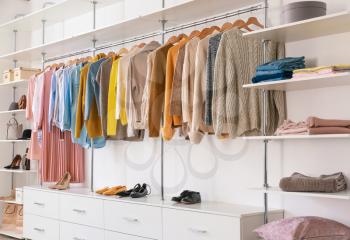 Big wardrobe with clothes in dressing room�