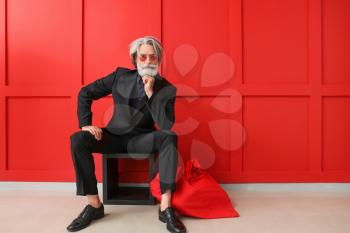 Portrait of stylish Santa Claus with bag indoors�