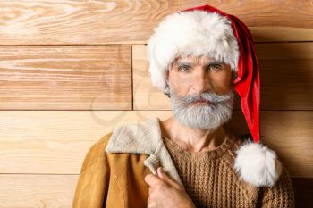 Portrait of stylish Santa Claus on wooden background�