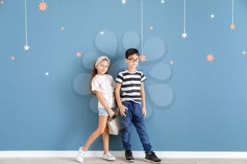 Cute fashionable children near color wall�