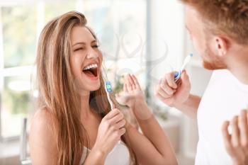 Young couple brushing teeth at home�