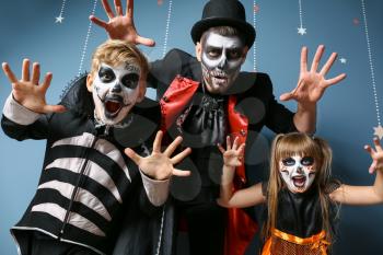 Father with children in Halloween costumes on color background�