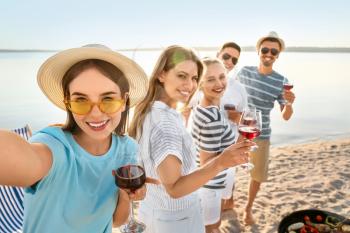 Friends taking selfie at barbecue party near river 