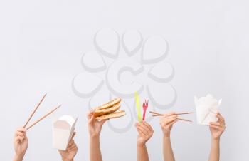 Many hands with food containers, pizza and cutlery on light background�