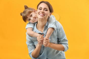 Portrait of happy mother and daughter on color background�