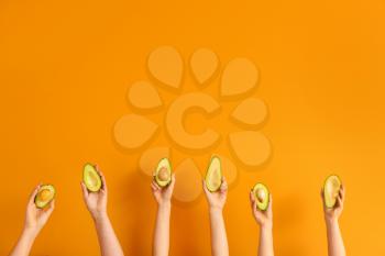 Female hands with fresh avocados on color background�