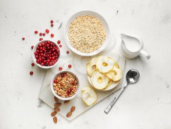 Tasty granola with fruits and milk on light background�