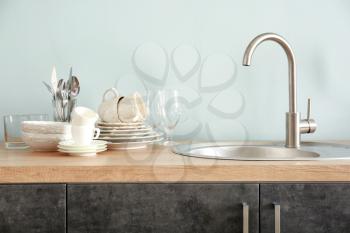 Set of clean dishware near kitchen sink�