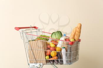 Shopping cart with products near color wall�