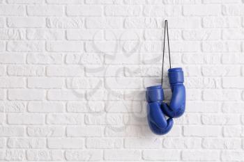 Pair of boxing gloves hanging on brick wall�