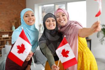Muslim women with Canadian flags at home�