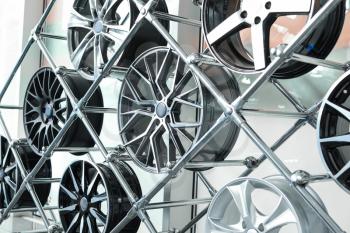 Different automotive wheels on stand in car salon�