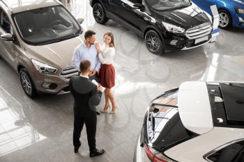 Couple buying new car in salon�