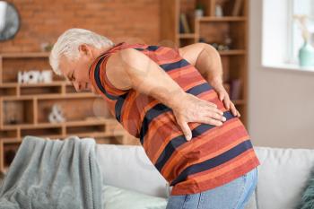 Senior man suffering from back pain at home�