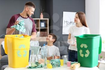 Family sorting garbage at home. Concept of recycling�