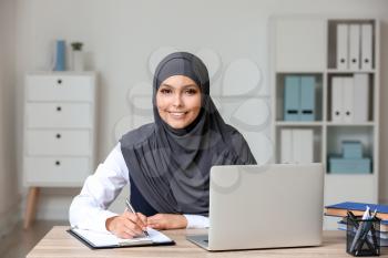 Beautiful Muslim student with laptop preparing for exam�