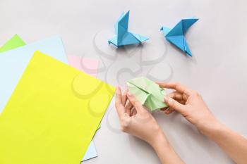 Woman making origami figures at table�