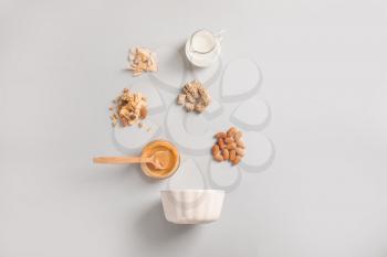 Bowl with tasty granola and ingredients on white background�