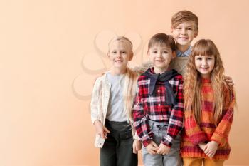 Cute little children in autumn clothes near color wall�