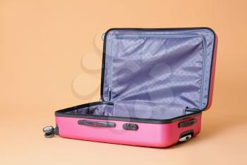 Open empty suitcase on color background. Travel concept�