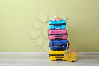 Packed suitcases near color wall. Travel concept�