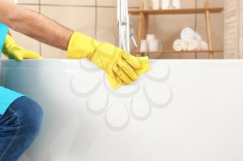 Male janitor doing cleanup in bathroom�
