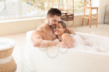 Happy young couple taking bath together�