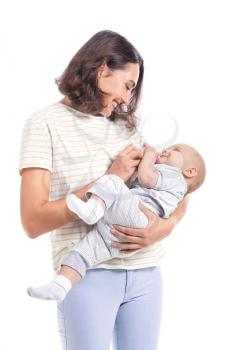 Mother feeding baby with milk from bottle on white background�