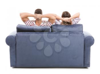 Young couple sitting on sofa against white background, back view�