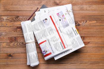 Many newspapers on wooden background�