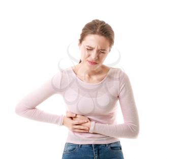 Young woman suffering from stomachache on white background�