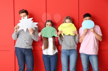 Group of young people with blank speech bubbles on color background�