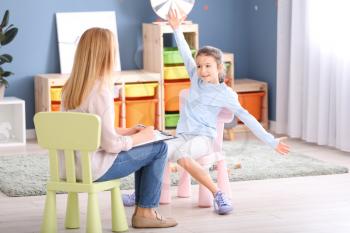 Psychologist working with little girl indoors�