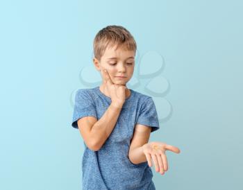 Little boy with fish oil pill on color background�
