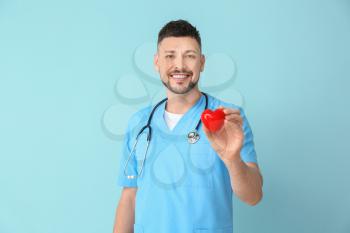 Male cardiologist on color background�