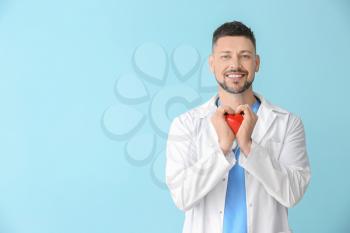 Male cardiologist on color background�