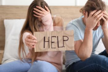 Worried young couple in debt at home�